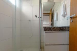 a bathroom with a glass shower and a sink at Veja Este Apê Completo! - PS505 in Maringá +11 photos