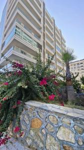 a large building with pink flowers in front of it at Arcadia homes avsallar in Alanya