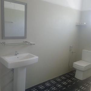 a white bathroom with a sink and a toilet at Senu's place in Matara