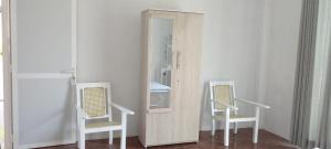 a mirror in a room with two chairs at Senu's place in Matara