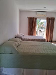 a large bed in a bedroom with a window at Suíte independente em condomínio privado in Ananindeua