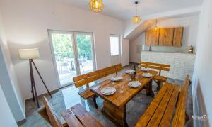 comedor con mesa de madera y bancos en Villa Selak, en Mostar