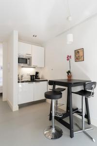 a kitchen with a black table and two stools at Tweede Laurierdwarsstraat Apartment in Amsterdam