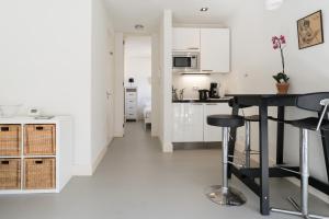 a kitchen with white cabinets and a black table at Tweede Laurierdwarsstraat Apartment in Amsterdam +9 photos