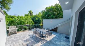 Un patio con mesa y sillas y una escalera. en Villa Selak, en Mostar