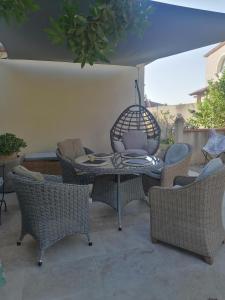 a patio with a table with chairs and a bird cage at Bastide YSATIS in Coulobres +9 photos