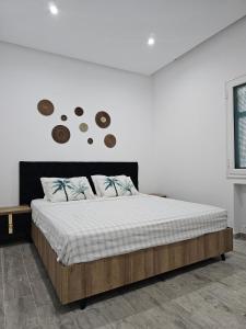 a bed in a bedroom with a white wall at Chic Apartment Near the Sea in Yasmine