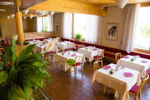 a dining room with white tables and chairs at Albergo Benito in Ponte nellʼAlpi