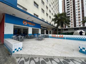 a restaurant with tables and chairs outside of a building at Praia da Mirim - Apto a 100m do Mar in Samaritá