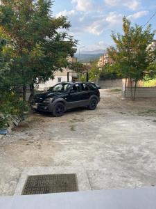 ein schwarzes Auto parkt auf einem Parkplatz in der Unterkunft City & Canyon - Modern Comfort in Çorovodë + 10 Fotos