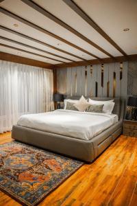 a bedroom with a large bed and a rug at Sanctum Suites Luxe 2BR in Kurseong, Scenic Views in Kurseong