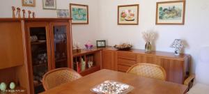 a dining room with a wooden table and chairs at Appartamento vicino al mare in Lizzano