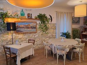 a dining room with two tables and chairs and a stone wall at Florivana Boutique Hotel in San Pietro in Cariano