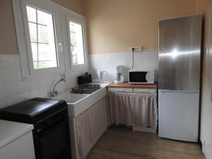 a small kitchen with a sink and a refrigerator at Appartement Albizia-Résidence Les Glycines in Eugénie-les-Bains