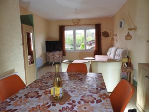 a dining room with a table and a bottle of wine at Appartement Albizia-Résidence Les Glycines in Eugénie-les-Bains