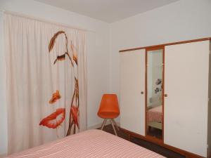 a bedroom with a bed and a mirror and a chair at Appartement Albizia-Résidence Les Glycines in Eugénie-les-Bains