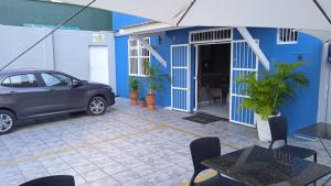a blue building with a car parked in a courtyard at Hotel Netuno Beach in Fortaleza +40 photos