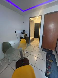 a room with a table and chairs and a microwave at Ice Flat Comfort in Garanhuns