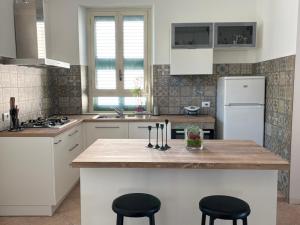 a kitchen with a kitchen island with two black stools at Ai piedi del Morrone in Tocco da Casauria
