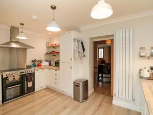 a kitchen with white cabinets and a stove top oven at Christlow Cottage in Bridlington