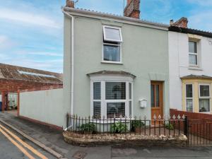 a white house with a fence in front of it at Christlow Cottage in Bridlington