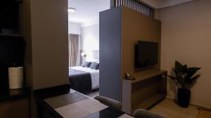 a hotel room with a bed and a tv at Republica Suites - Departamento Nivel Ejecutivo1 in San Fernando del Valle de Catamarca
