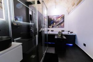 a bathroom with a shower and a painting on the wall at Suite Piazza Vittorio Emanuele in Mesagne