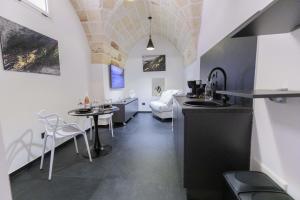 a kitchen and living room with a table and chairs at Suite Piazza Vittorio Emanuele in Mesagne