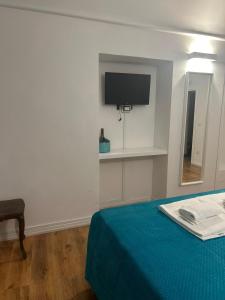 una stanza con un letto e una TV su una parete di AH Suite Montecitorio a Roma