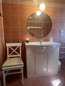 a bathroom with a sink and a mirror and a chair at Domek w niebie in Kazuń Bielany +36 photos