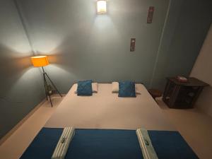 a bedroom with a large bed with blue pillows at Upaja Ghar Homestay in Guwahati +2 photos