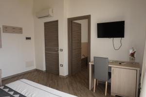 ein Schlafzimmer mit einem Bett und einem Schreibtisch mit Computer in der Unterkunft Hotel Il Platano in San Teodoro