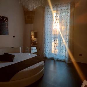 a bedroom with a bed and a window with curtains at Suite Piazza Vittorio Emanuele in Mesagne