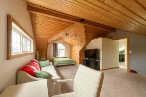 a living room with a couch and a tv at Quaint Attic Suite with Heated Pool Year-Round in Victoria