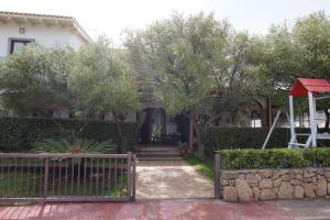 ein Haus mit Zaun und Schaukel in der Unterkunft Hotel Il Platano in San Teodoro