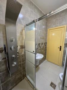 a bathroom with a shower and a toilet and a sink at شقق الخامسه الفاخرة Al Amer Luxury Apartments in Aqaba +79 photos