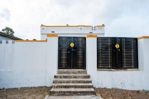 ラーメーシュワラムにあるRameswaram Homestayの階段のある白い建物の一対のドア +2枚の写真