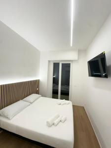 una camera con un letto bianco e due asciugamani bianchi di Lanterna View Apartment - Sea View a Genova Altre 33 foto