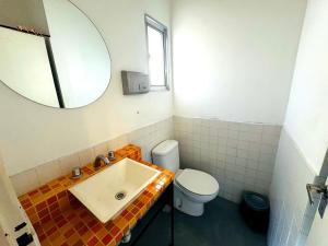 a bathroom with a sink and a toilet and a mirror at Quinba Hostel in Buenos Aires