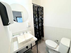 a bathroom with a toilet and a sink and a mirror at Quinba Hostel in Buenos Aires