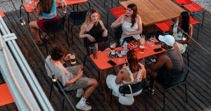 a group of people sitting at tables on a deck at Yellowsquare Athens in Athens