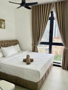 a teddy bear sitting on a bed in a bedroom at Neu Suites Near KLCC in Kuala Lumpur