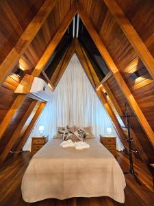 ein Schlafzimmer mit einem großen Bett im Dachgeschoss in der Unterkunft Cabana Quatro Estações - Paty do Alferes - Rio de Janeiro in Paty do Alferes