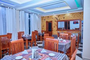 a restaurant with tables and chairs in a room at Aves Executive Hotel in Arusha