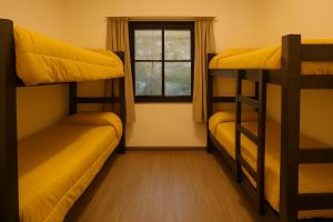 a room with three bunk beds and a window at Quinba Hostel in Buenos Aires