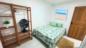 a bedroom with a bed and a fan and a door at Casa espaçosa - Luar da Guarda in Palhoça