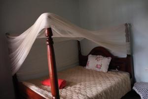 a bed with a canopy in a bedroom at Wycliffˋs Eco Lodge in Kabale