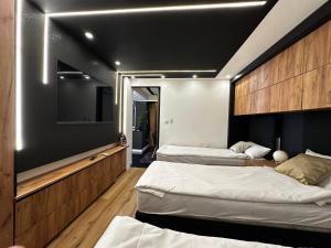 a room with three beds and a flat screen tv at Vila CITY by BEN&CO in Sarajevo +35 photos