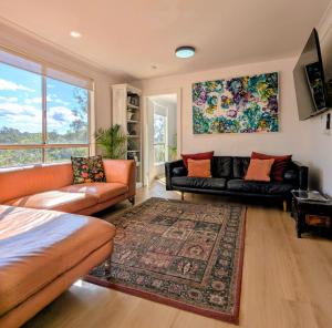 a living room with two couches and a rug at Blue Mountains Urban Farm Stay near Sydney in Hazelbrook