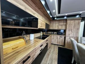 a kitchen with wooden cabinets and a sink at Vila CITY by BEN&CO in Sarajevo